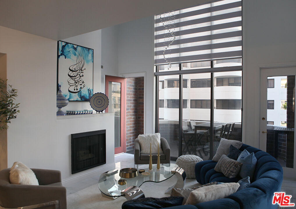 10550 Wilshire Boulevard, Unit 502 Los Angeles, CA 90024 - Photo 8 of 25 a living room with furniture a fireplace and a large window