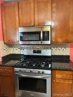 a kitchen with granite countertop a stove and a microwave