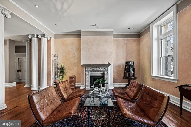 a living room with furniture fireplace and a large window