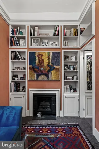 a living room with furniture a rug and a bookshelf