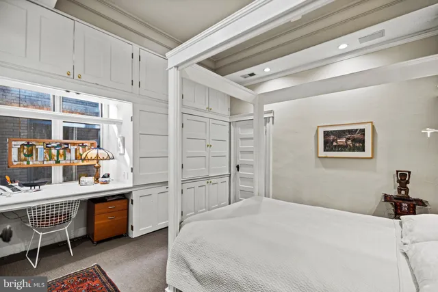 a bedroom with a bed cabinets and window