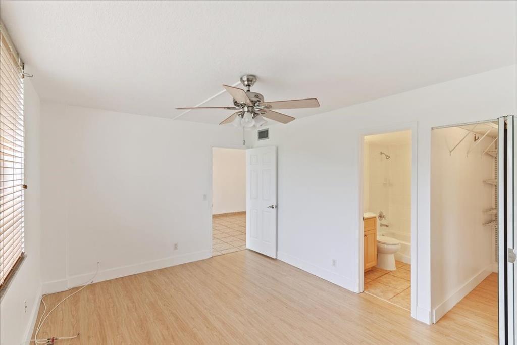 9470 Poinciana Place, Unit 103 Davie, FL 33324 - Photo 21 of 27 a view of a room with wooden floor and a ceiling fan