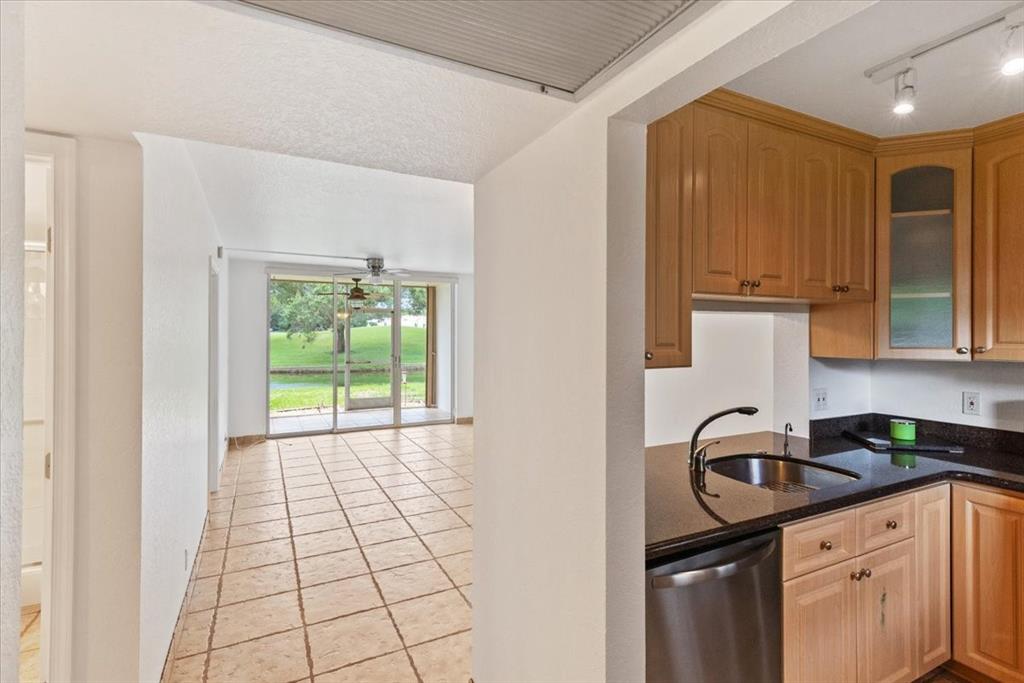 9470 Poinciana Place, Unit 103 Davie, FL 33324 - Photo 9 of 27 a kitchen with a sink a stove cabinets and a window