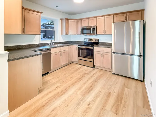 a kitchen with a sink white cabinets and white appliances