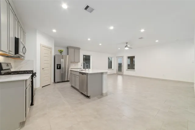 a kitchen with white cabinets and stainless steel appliances