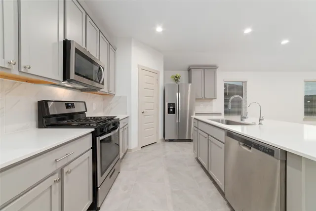 a kitchen with white cabinets and stainless steel appliances