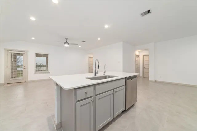 a view of kitchen with kitchen island white cabinets and stainless steel appliances