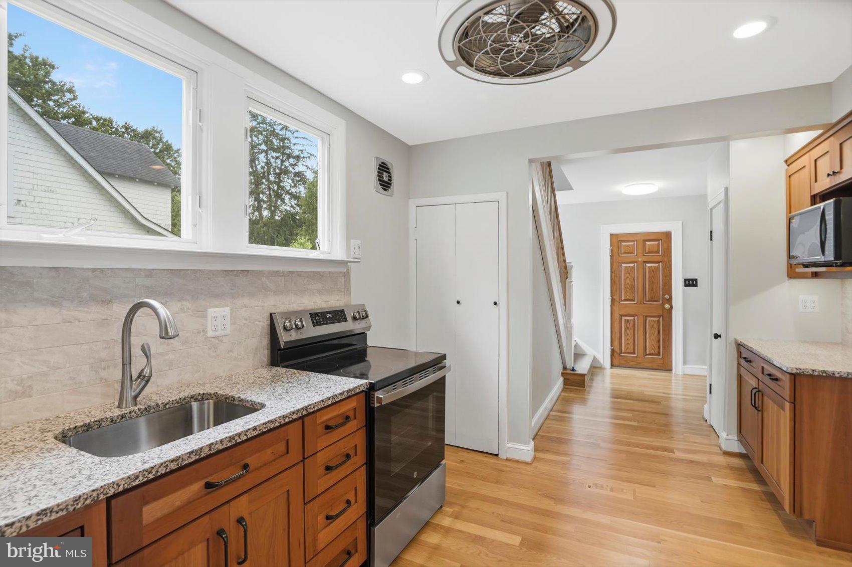 24 Normal Terrace Baltimore, MD 21286 - Photo 12 of 37 a kitchen with stainless steel appliances granite countertop a sink and a stove with wooden floor