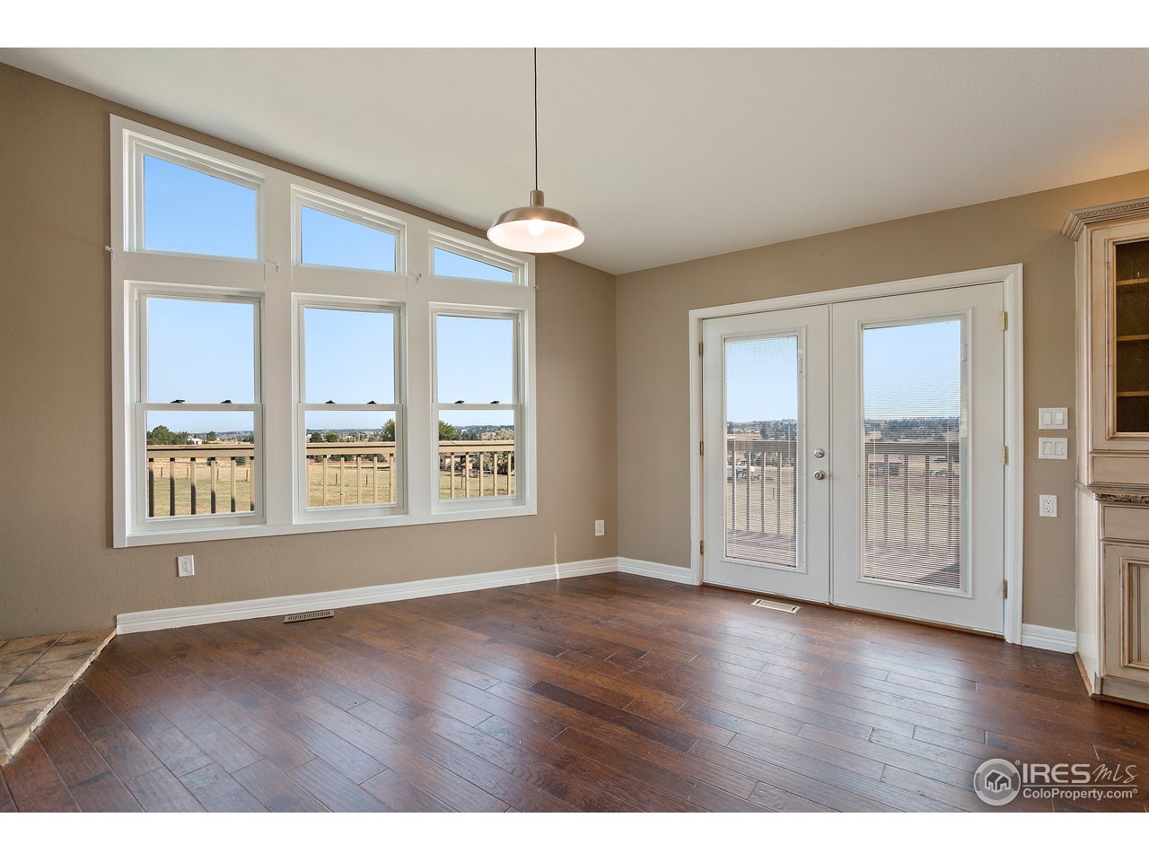 9088 North Awl Road Parker, CO 80138 - Photo 9 of 40 an empty room with wooden floor and windows