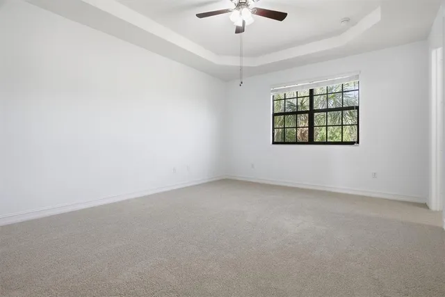 en empty room with windows and ceiling fan