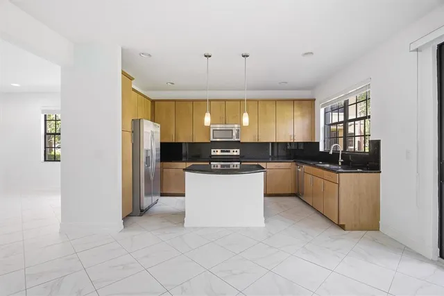 a kitchen with stainless steel appliances a refrigerator sink and cabinets