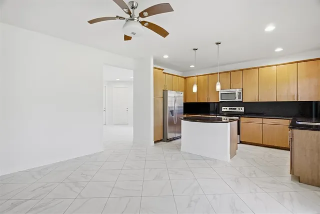 a large white kitchen with a refrigerator a stove top oven a sink and dishwasher