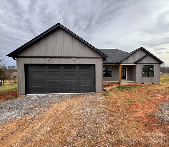 a front view of house with yard and trees in the background