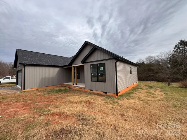 a view of yellow house with wooden fence