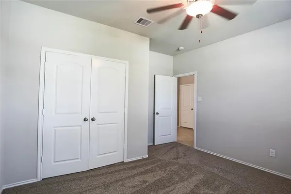 an empty room with a window and a fan