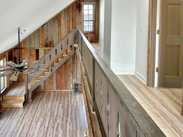 a view of staircase with wooden floor and next to a window