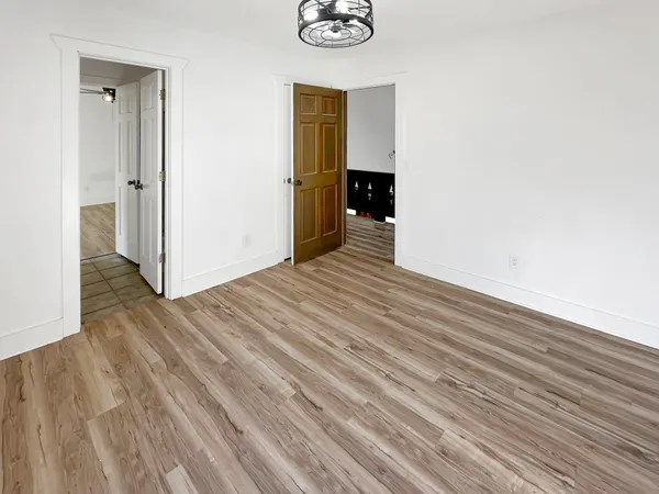 a view of a room with wooden floor and white doors