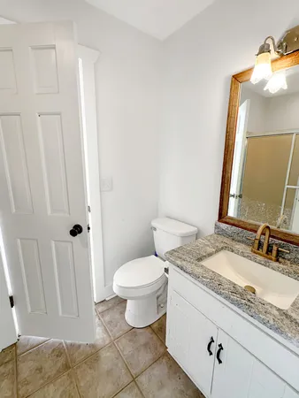 a bathroom with a granite countertop sink and a mirror