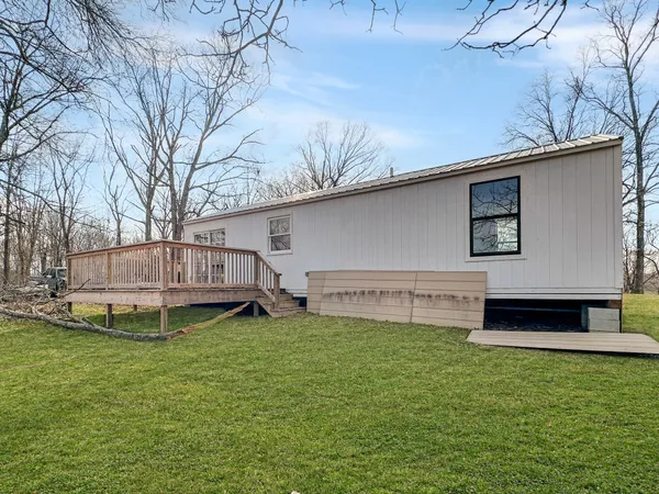 a view of an empty room with wooden floor fireplace and a window