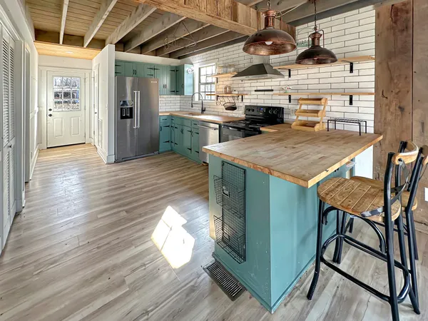 a open kitchen with stainless steel appliances granite countertop a stove and a refrigerator