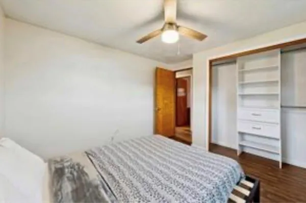 a bedroom with a bed and a ceiling fan