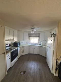 a kitchen with a white cabinets a sink a window and stainless steel appliances