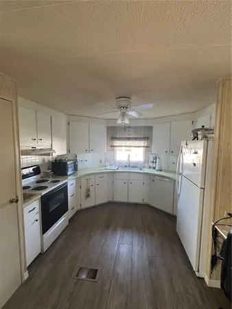 a kitchen with a white cabinets a sink a window and stainless steel appliances