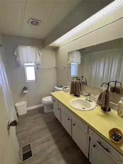 a bathroom with a granite countertop sink a toilet and mirror