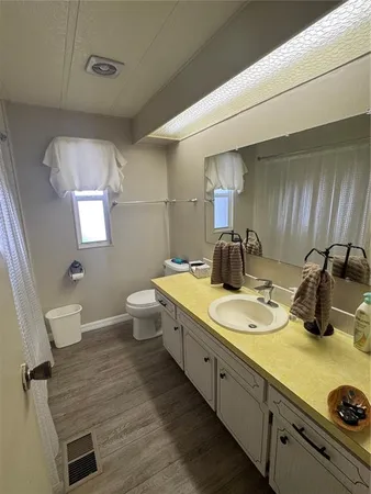 a bathroom with a granite countertop sink a toilet and mirror