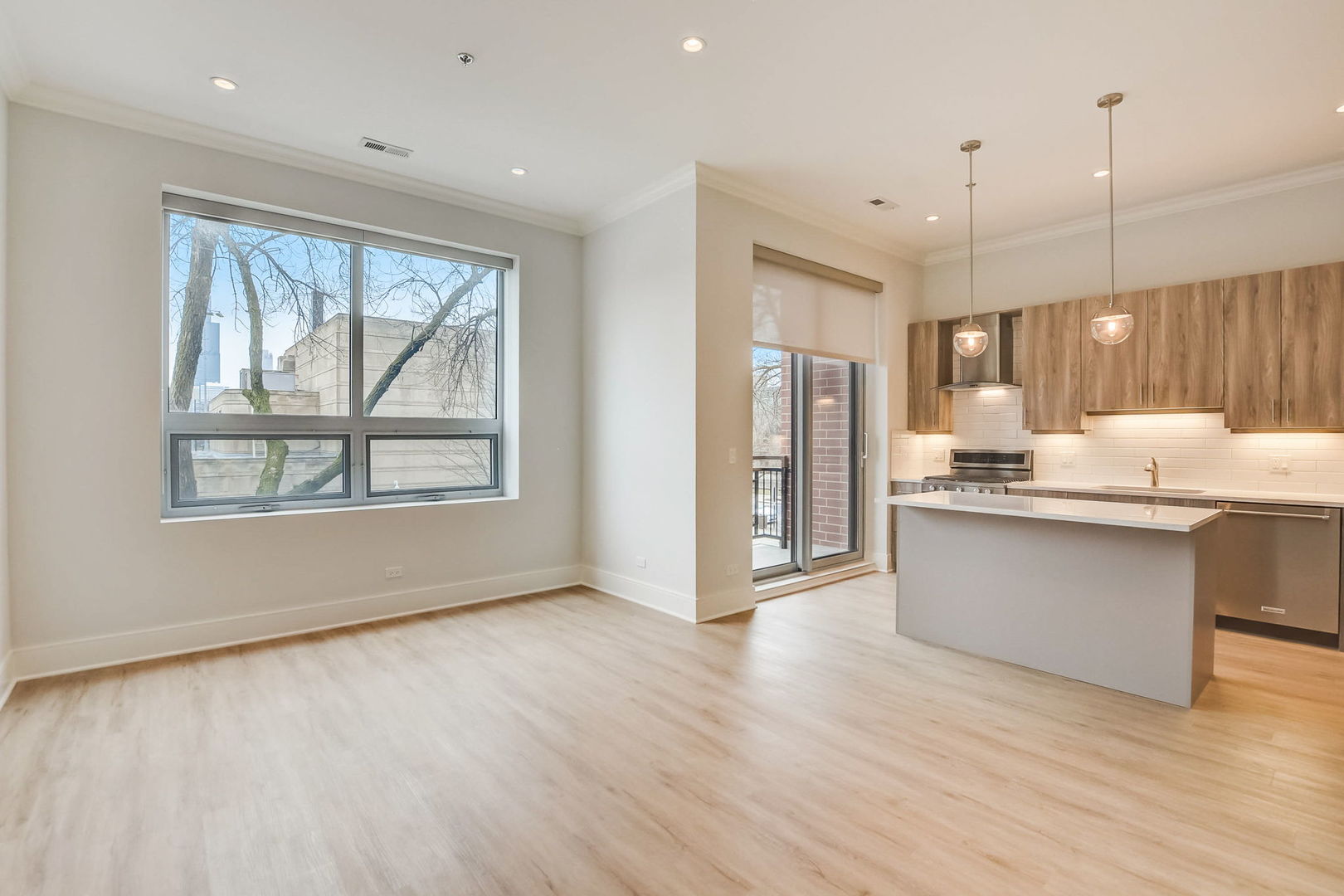 128 South Laflin Street, Unit 314 Chicago, IL 60607 - Photo 5 of 12 a kitchen with stainless steel appliances granite countertop a refrigerator a sink dishwasher and a large window with wooden floor