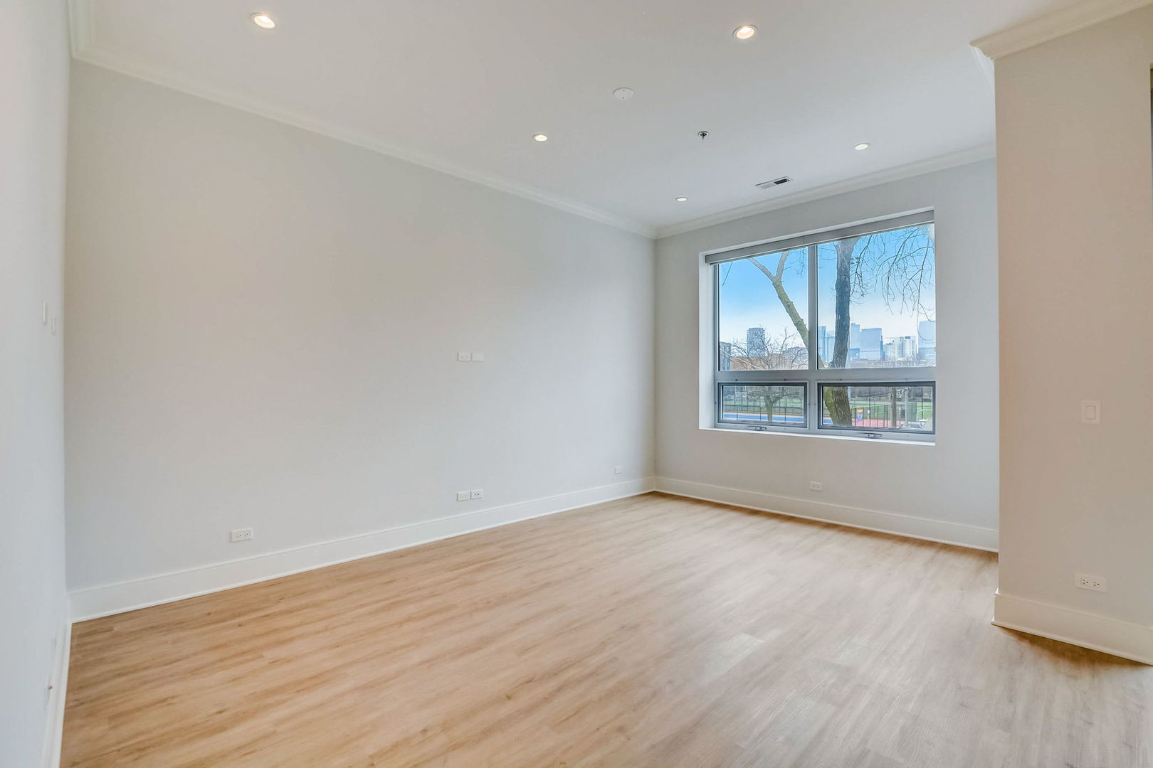128 South Laflin Street, Unit 314 Chicago, IL 60607 - Photo 9 of 12 a view of an empty room with wooden floor and a window