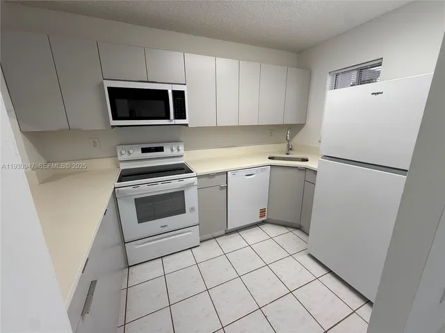 a kitchen with a stove a microwave and a refrigerator