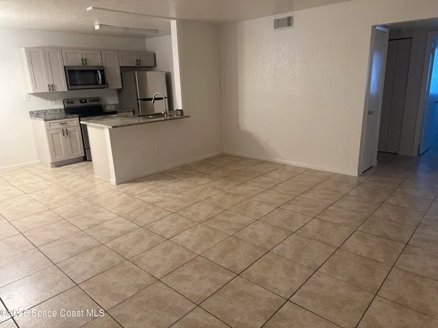 a kitchen with stainless steel appliances a sink a stove top oven a counter top space and cabinets