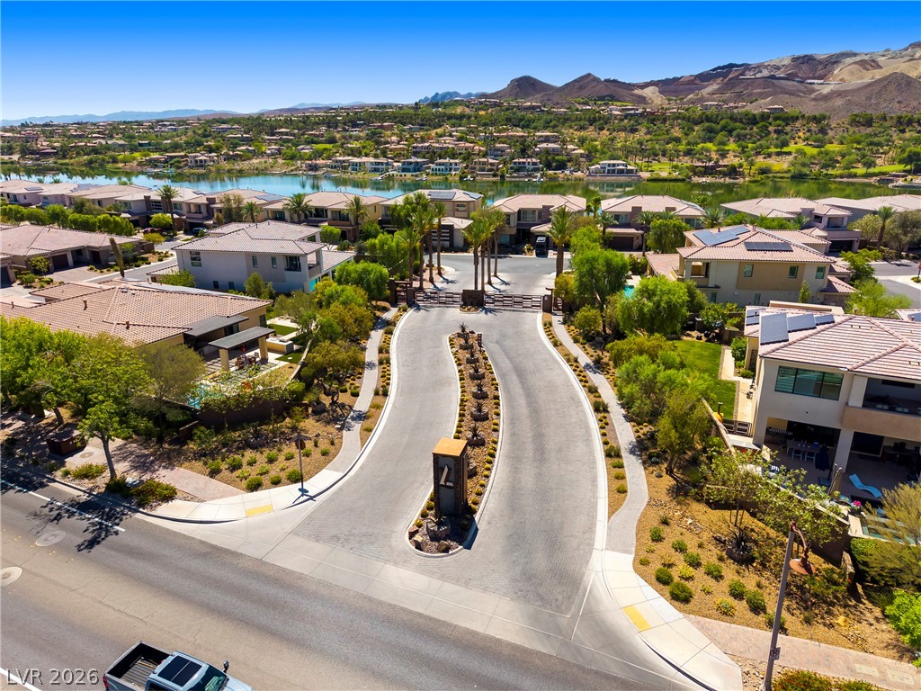 45 Garibaldi Way Henderson, NV 89011 - Photo 51 of 74 An aerial perspective showcases a gated community with verdant landscaping, tranquil lake views, and majestic mountain backdrops.