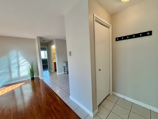 a view of a hallway view with wooden floor and a bathroom