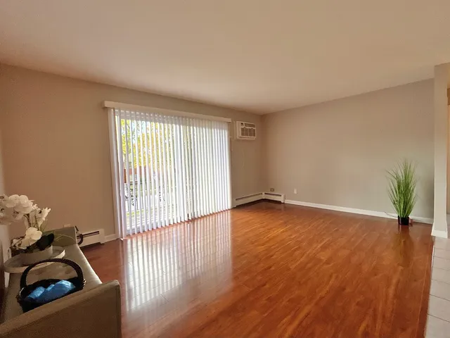 a view of a livingroom with wooden floor and a window