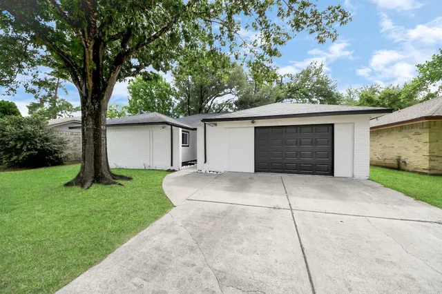 a front view of house with a garden