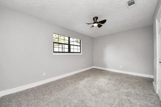 a view of room with a ceiling fan and window