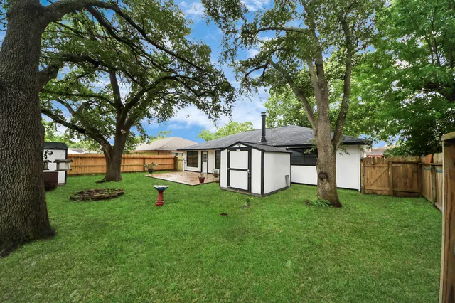 a view of a house with backyard and a tree