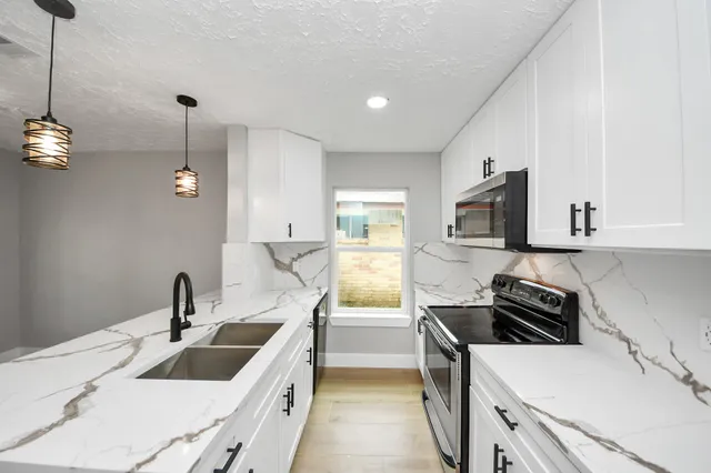 a kitchen with a sink stove and wooden floor