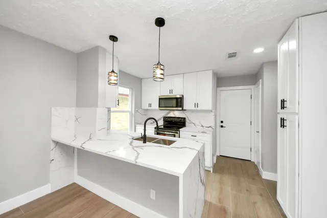 a kitchen that has a sink and a stove