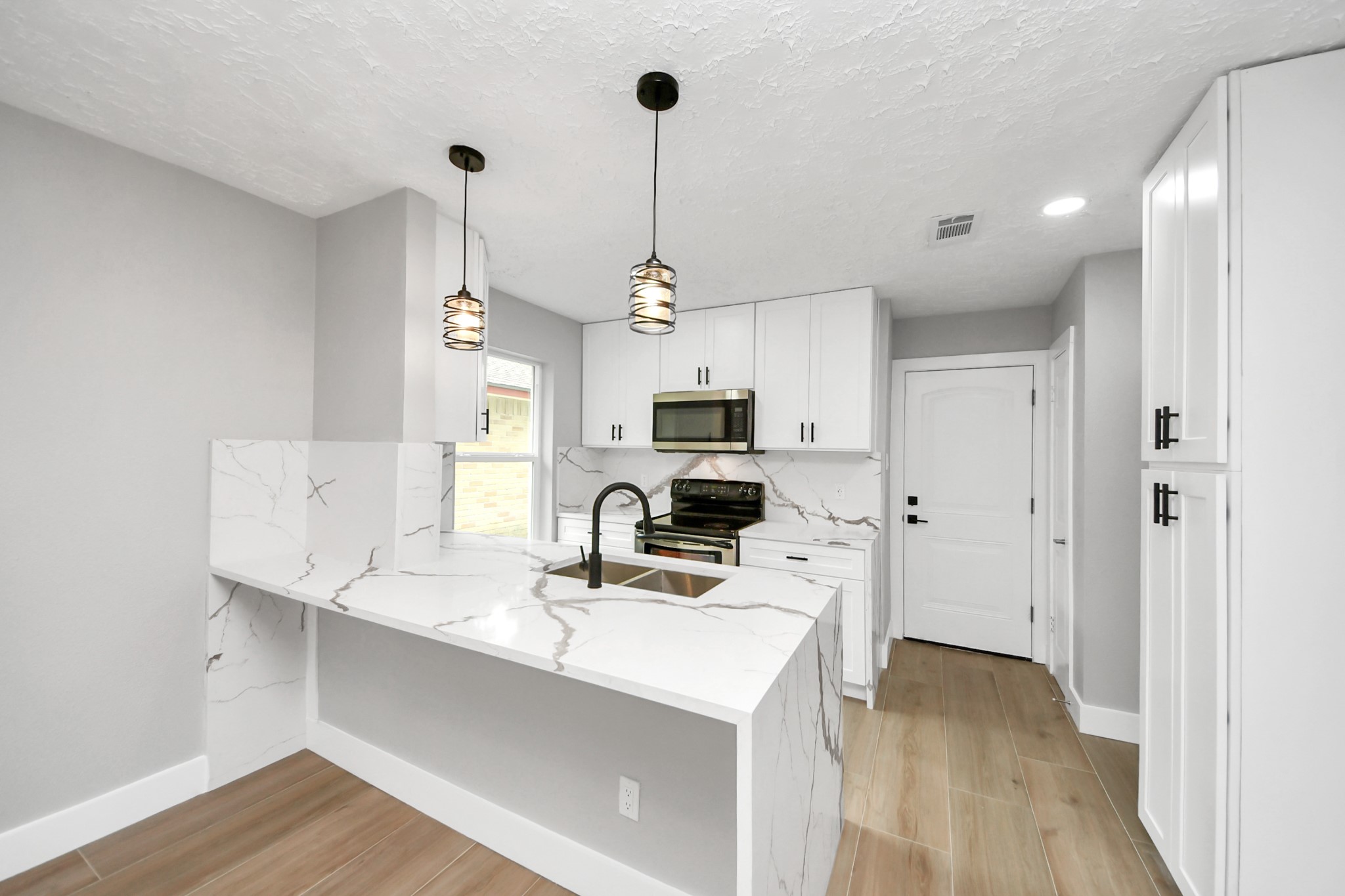20010 Cottonglade Lane Humble, TX 77338 - Photo 8 of 27 a kitchen with kitchen island a sink stainless steel appliances and cabinets