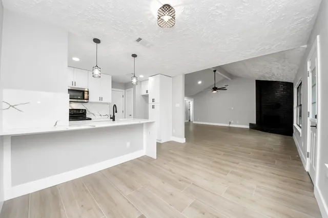 a kitchen with kitchen island a sink stainless steel appliances and cabinets