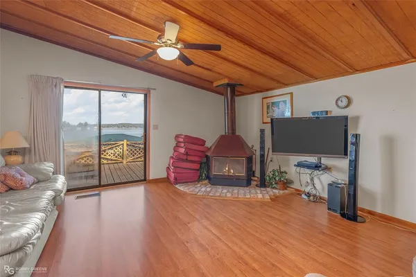a living room with furniture a flat screen tv and floor to ceiling window