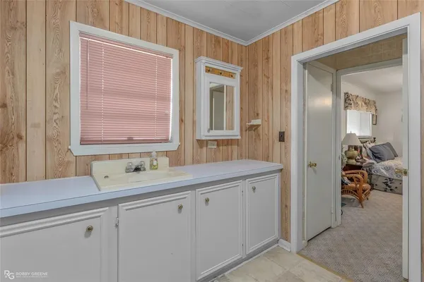 a en suite bathroom with a sink a mirror and next to a window
