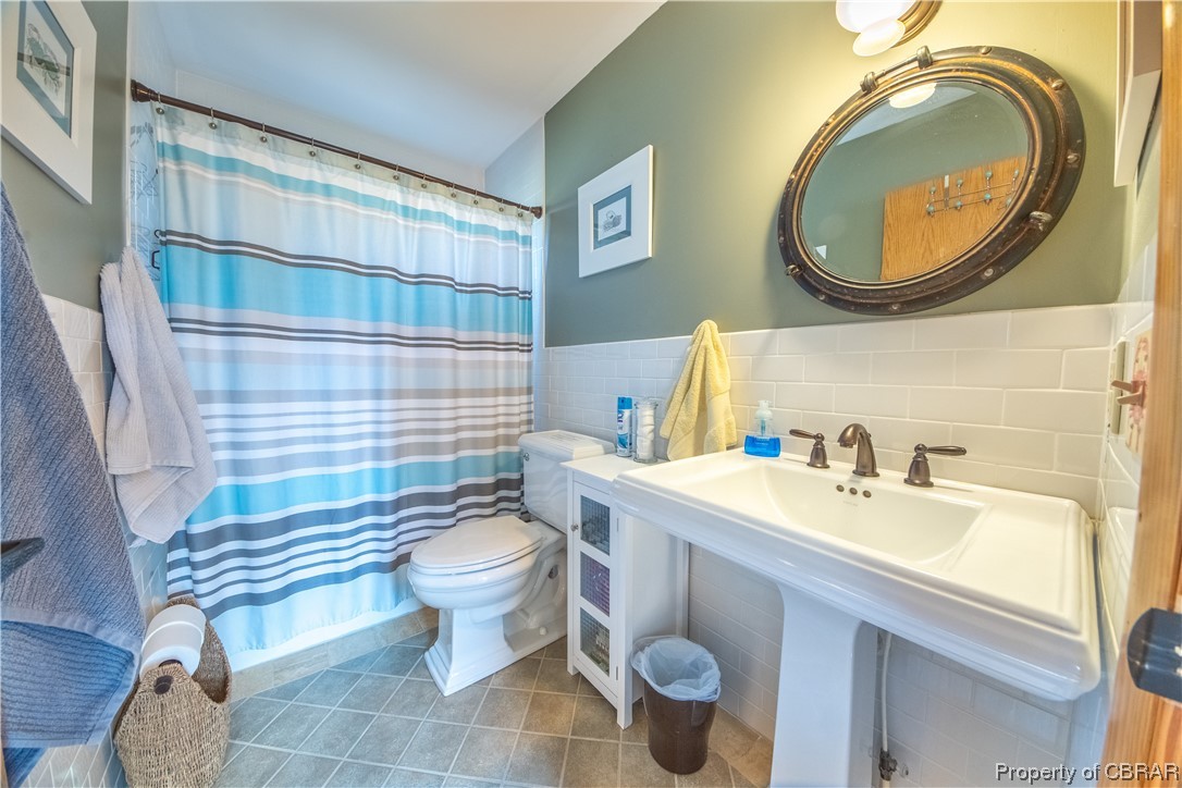 1239 Kelley Neck Road Lancaster, VA 22503 - Photo 43 of 48 Bathroom with toilet, tile walls, tile flooring, backsplash, and sink