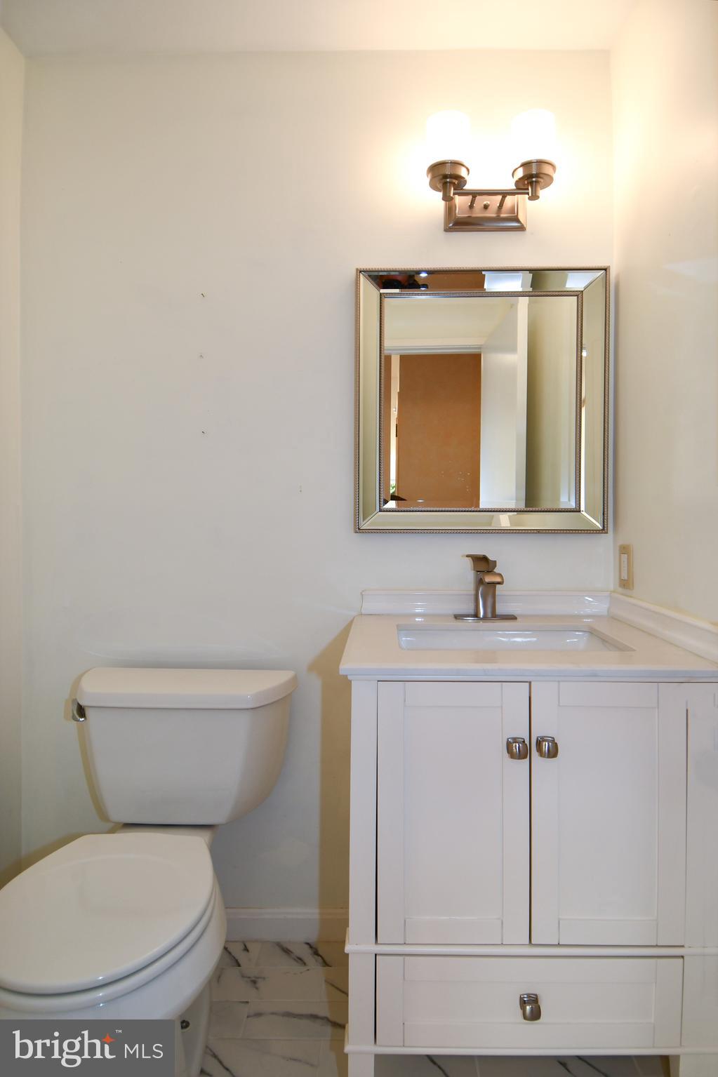 39 Windwhisper Lane Annapolis, MD 21403 - Photo 45 of 64 a bathroom with a toilet a sink and mirror