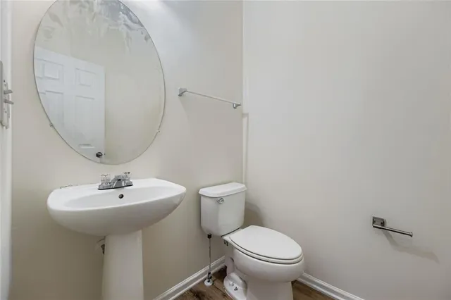 a bathroom with a sink a toilet and mirror