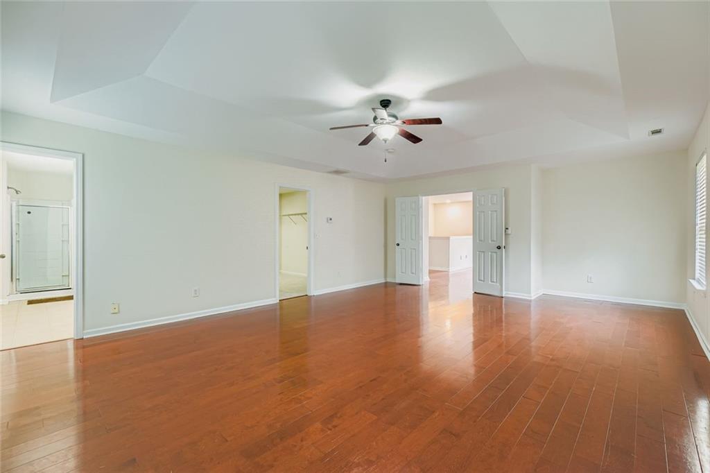 700 Kirkly Way Fairburn, GA 30213 - Photo 17 of 31 a view of an empty room with a window and wooden floor