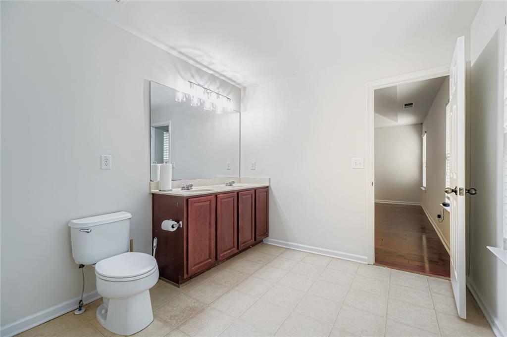 700 Kirkly Way Fairburn, GA 30213 - Photo 19 of 31 a bathroom with a toilet sink vanity and mirror